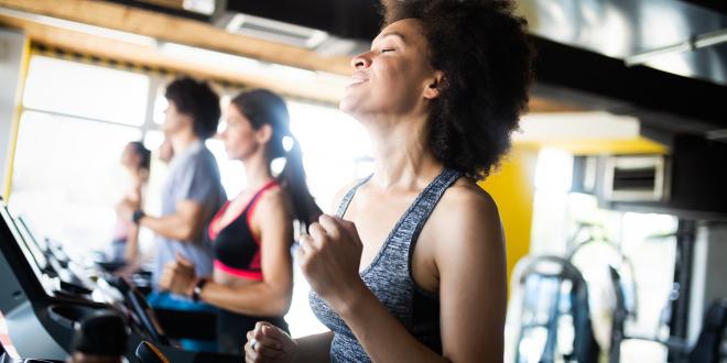 Happy group of fit people training in gym.