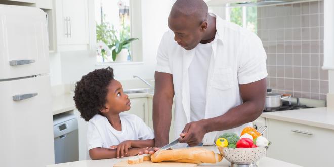 A father and son cooking with healthy foods in the kitchen.