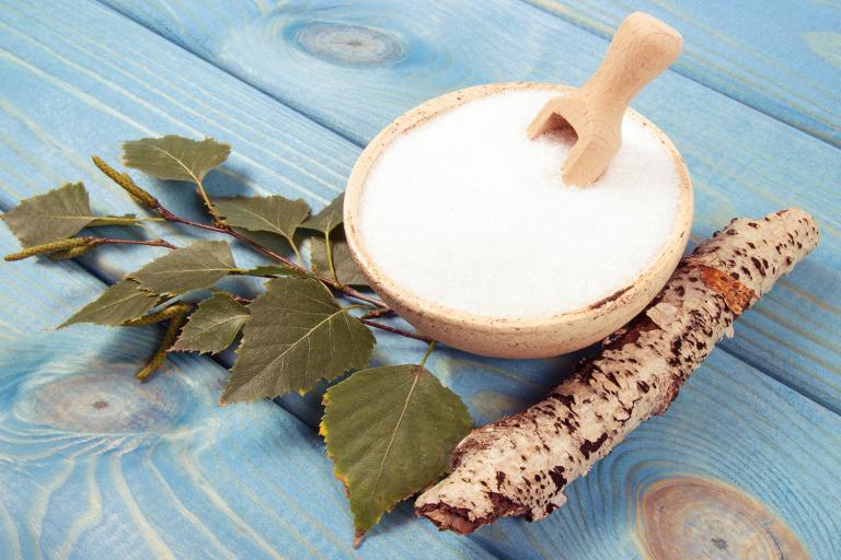 Birch sugar on blue wooden background.